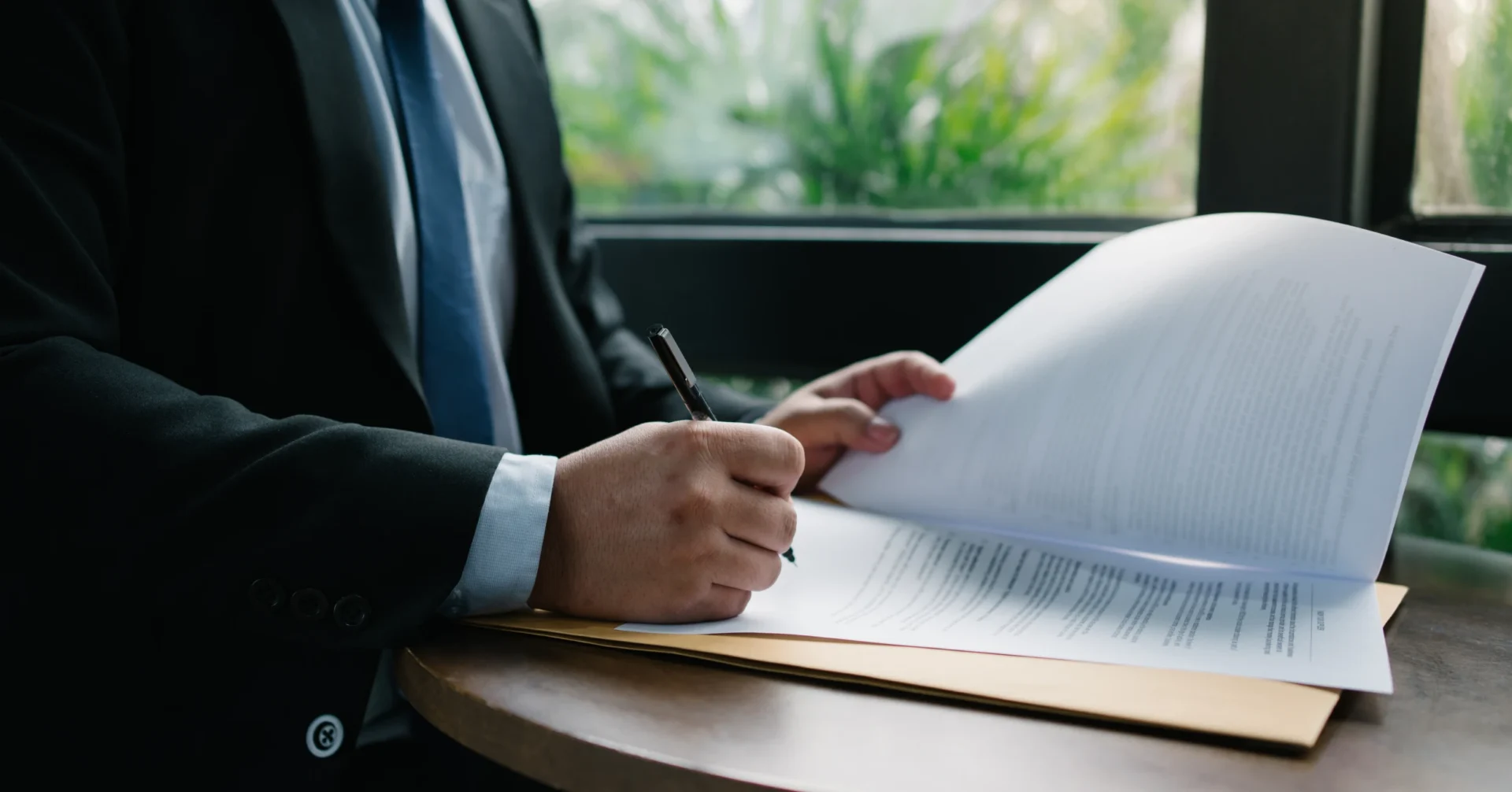 Businessman signing documents at table